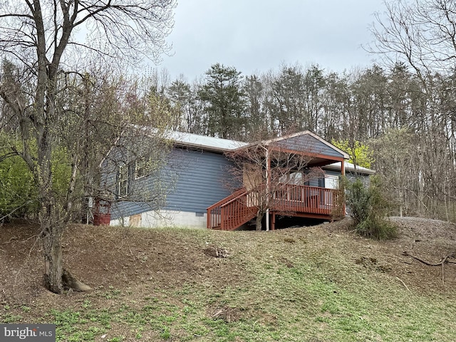 rear view of house with crawl space, a deck, and stairway