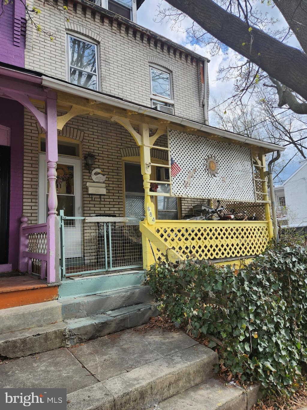 doorway to property featuring covered porch and brick siding