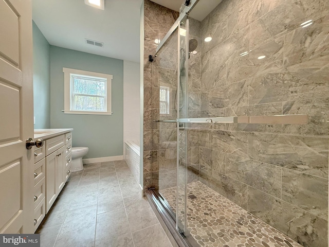 bathroom featuring vanity, visible vents, toilet, a stall shower, and baseboards