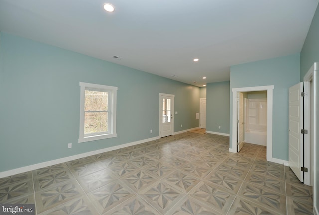 unfurnished room with baseboards, visible vents, and recessed lighting