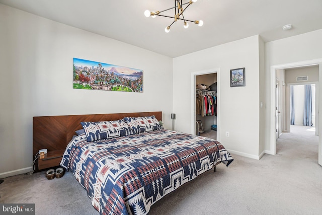 carpeted bedroom featuring baseboards, a notable chandelier, a spacious closet, and visible vents
