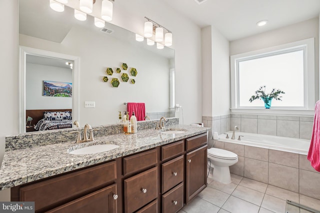 ensuite bathroom featuring double vanity, visible vents, a sink, and connected bathroom