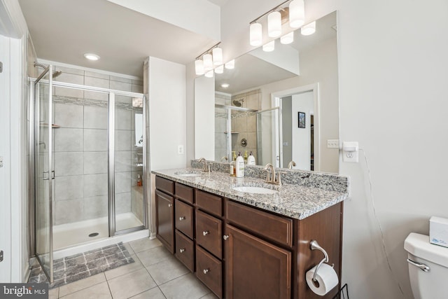 bathroom with a sink, tile patterned flooring, toilet, and a stall shower