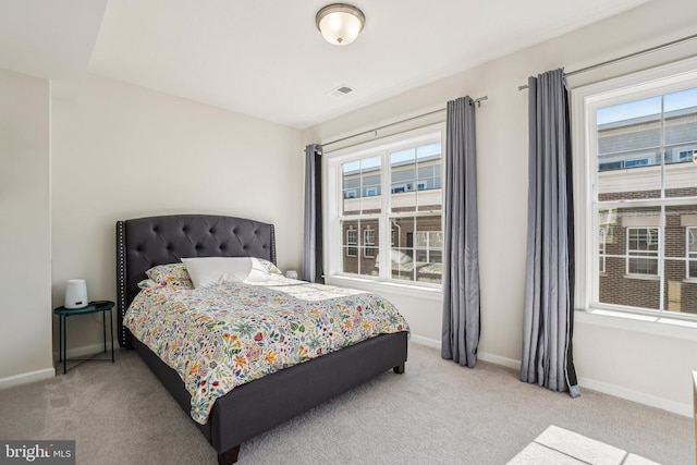 bedroom featuring baseboards, multiple windows, visible vents, and carpet floors