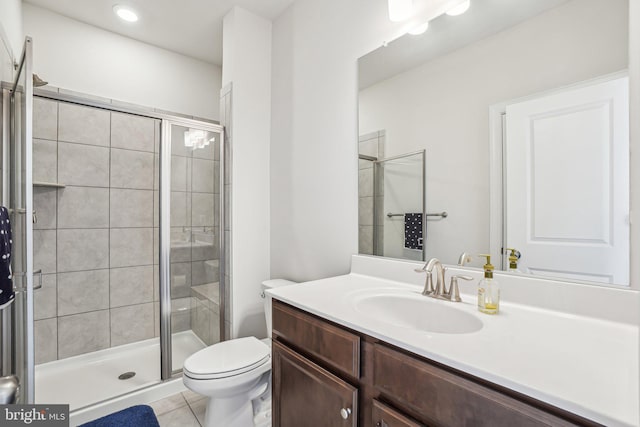 full bathroom featuring toilet, tile patterned floors, a shower stall, and vanity