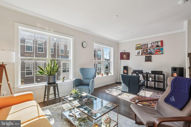 living area featuring crown molding, baseboards, and wood finished floors