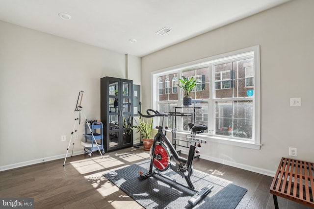 workout room with visible vents, baseboards, and wood finished floors