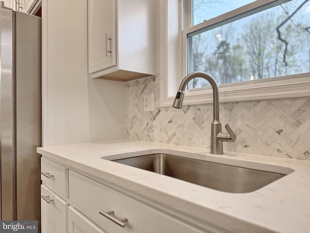9871 La Plata Pkwy, La Plata, MD 20646 - interior details featuring white cabinetry, tasteful backsplash, a sink, and freestanding refrigerator