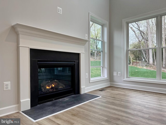 9871 La Plata Pkwy, La Plata, MD 20646 - room details featuring baseboards, visible vents, a glass covered fireplace, and wood finished floors