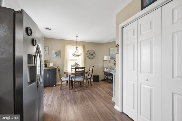 dining area featuring visible vents, baseboards, and wood finished floors