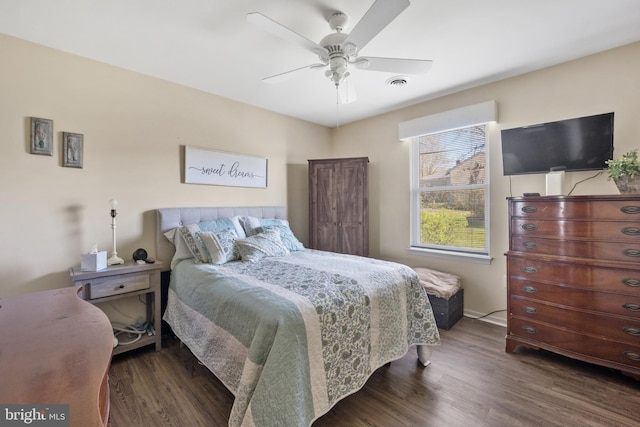 bedroom with wood finished floors, ceiling fan, baseboards, and visible vents