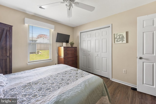 bedroom with dark wood-style flooring, a closet, baseboards, visible vents, and ceiling fan