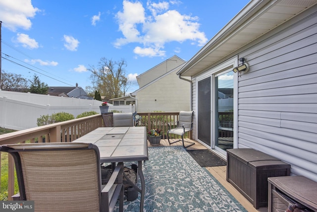 wooden deck with outdoor dining area and fence