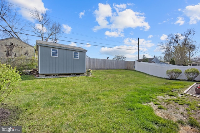 view of yard with a fenced backyard, a storage unit, and an outdoor structure