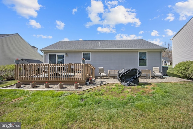 back of property featuring a patio area, a shingled roof, a deck, and a lawn