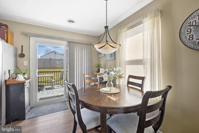 dining area with wood finished floors and visible vents