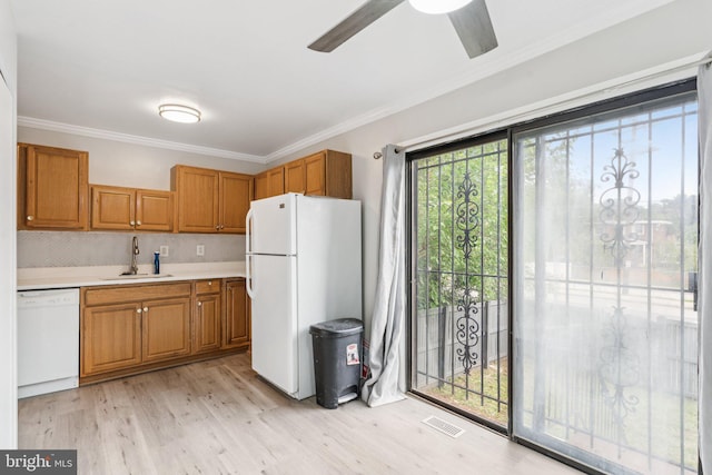 4647 6th St SE, Washington, DC 20032 - kitchen featuring white appliances, light wood-style floors, brown cabinets, a ceiling fan, and light countertops