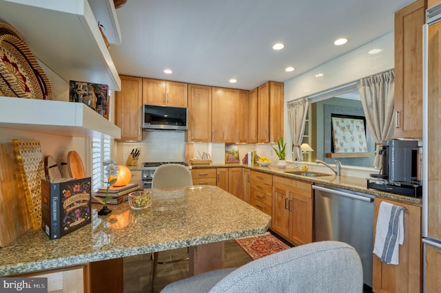 kitchen featuring recessed lighting, a sink, decorative backsplash, and stainless steel appliances