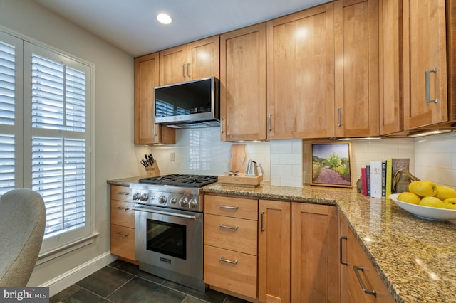 kitchen with stainless steel appliances, baseboards, light stone countertops, and plenty of natural light