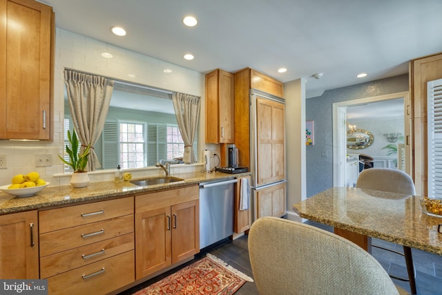 kitchen featuring a sink, light stone countertops, recessed lighting, and dishwasher