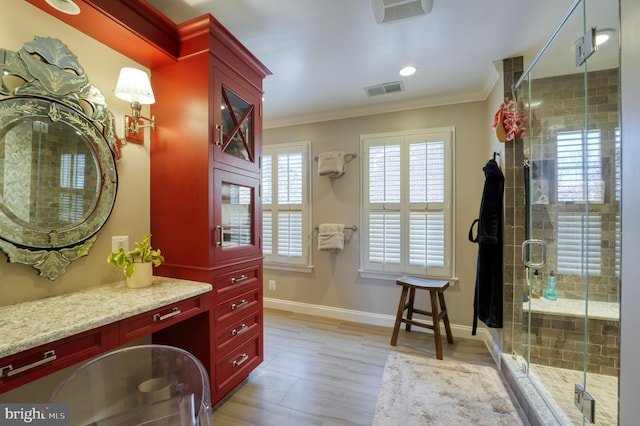 full bathroom featuring crown molding, vanity, wood finished floors, and visible vents