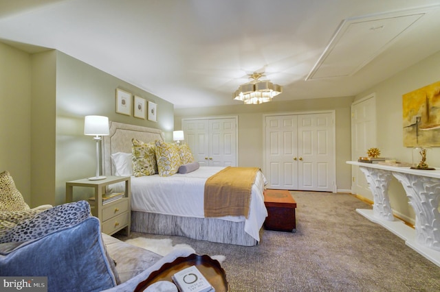 bedroom with an inviting chandelier, carpet floors, multiple closets, attic access, and baseboards
