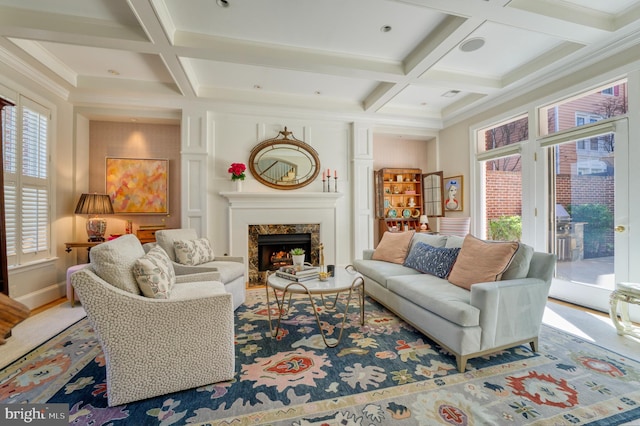 living area with beamed ceiling, a fireplace, and coffered ceiling