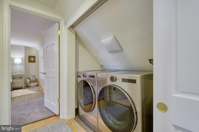 clothes washing area with independent washer and dryer, laundry area, and wood finished floors