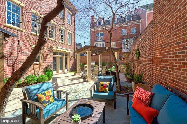view of patio featuring an outdoor living space with a fire pit, a pergola, and outdoor dining area