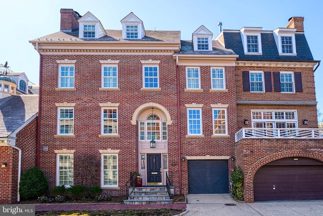view of front of property featuring brick siding, driveway, and a chimney