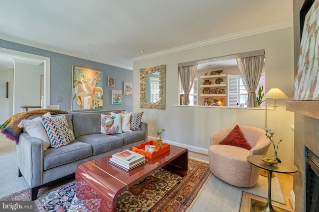 living room featuring crown molding, baseboards, and a fireplace