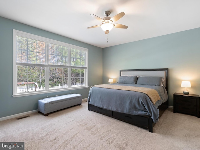bedroom with carpet floors, visible vents, a ceiling fan, and baseboards