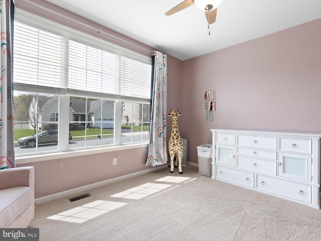 interior space featuring visible vents, baseboards, and ceiling fan