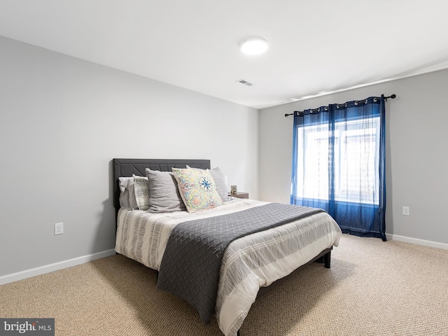 bedroom featuring light carpet, visible vents, and baseboards