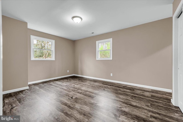 interior space with dark wood-type flooring and baseboards