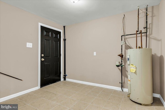 entryway featuring baseboards, electric water heater, and light tile patterned floors