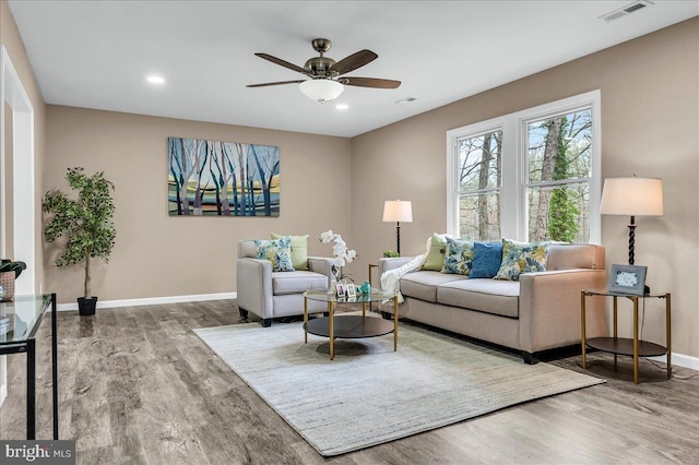 living room with visible vents, baseboards, ceiling fan, wood finished floors, and recessed lighting