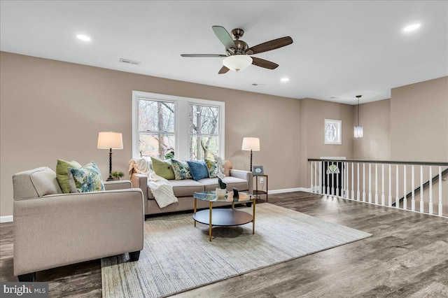 living area featuring baseboards, ceiling fan, wood finished floors, and recessed lighting