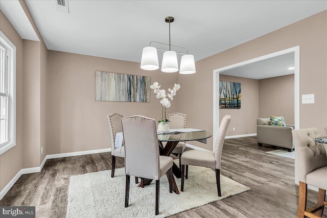 dining area featuring visible vents, baseboards, and wood finished floors