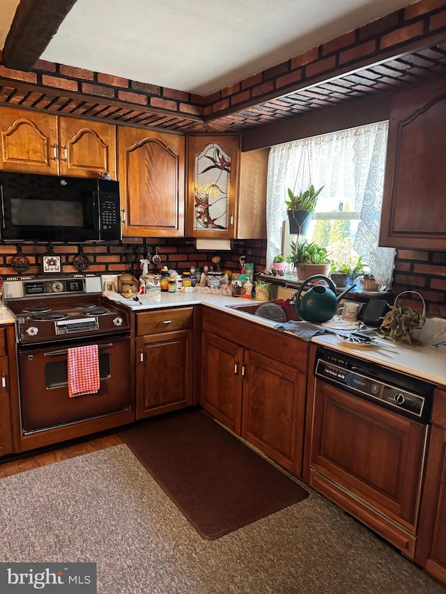 kitchen featuring light countertops, dishwasher, black microwave, and electric stove