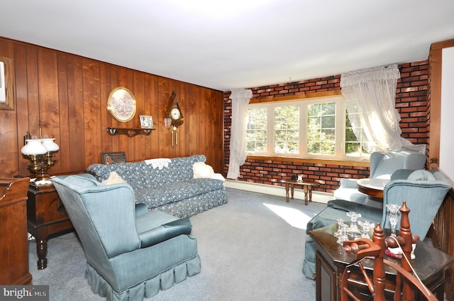 carpeted living room with wooden walls, brick wall, and baseboard heating