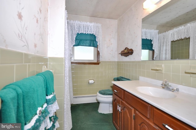 bathroom featuring vanity, baseboard heating, toilet, and tile walls