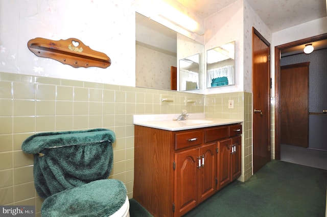 bathroom featuring vanity, wainscoting, and tile walls