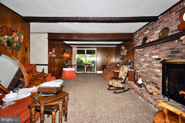carpeted living area with wood walls, a brick fireplace, and beam ceiling