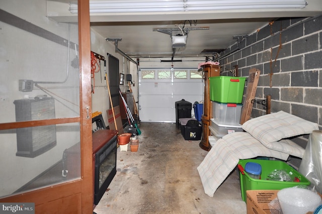 garage featuring concrete block wall and a garage door opener