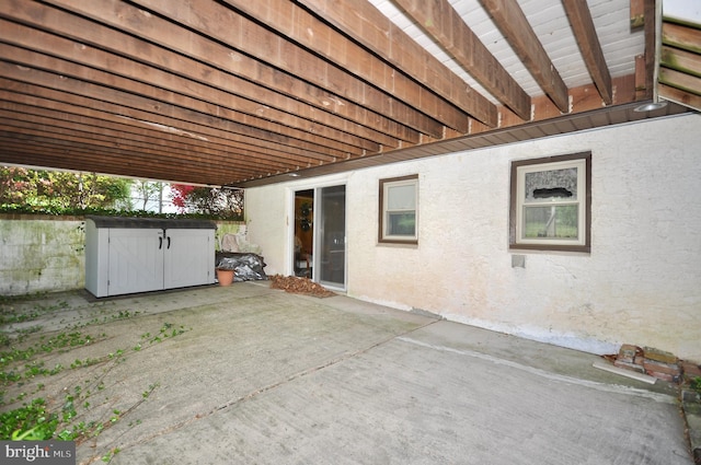 view of patio featuring a storage unit and an outbuilding