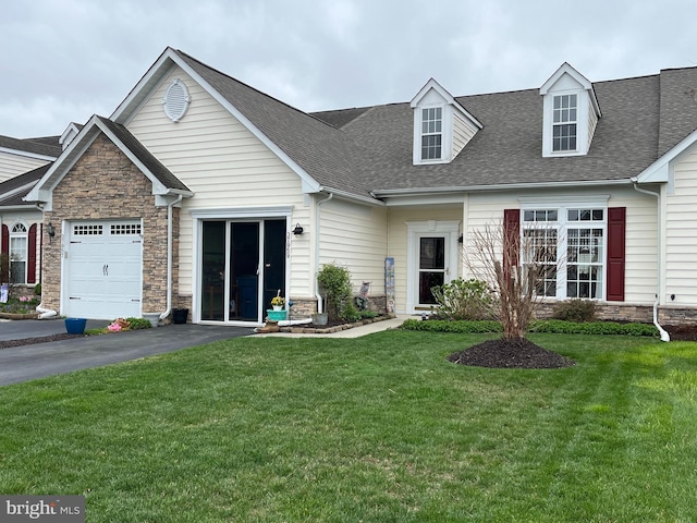 37959 Bayview Cir E, Selbyville, DE 19975 - view of front of house featuring an attached garage, a shingled roof, stone siding, and a front lawn