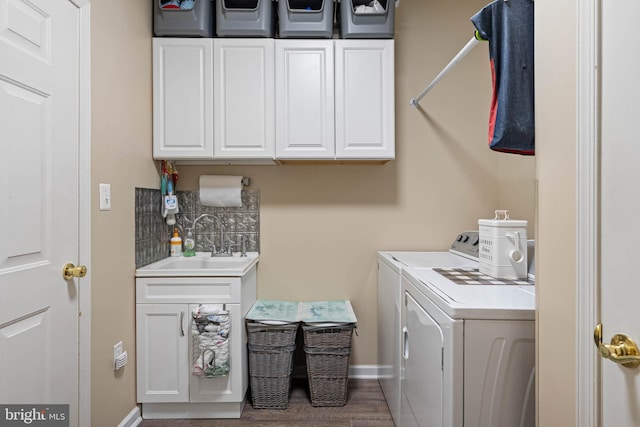 37959 Bayview Cir E, Selbyville, DE 19975 - laundry area featuring separate washer and dryer, wood finished floors, a sink, baseboards, and cabinet space