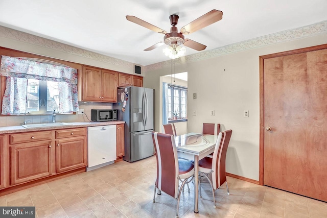 511 Chelton Ave, Burlington, NJ 08016 - kitchen featuring light countertops, a ceiling fan, a sink, brown cabinetry, and appliances with stainless steel finishes