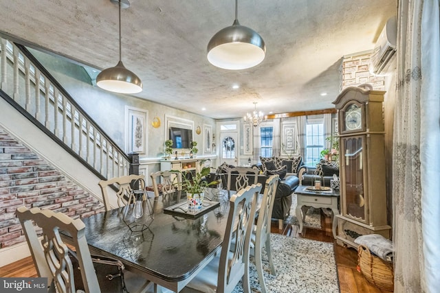 dining room with wood finished floors, a notable chandelier, and stairway